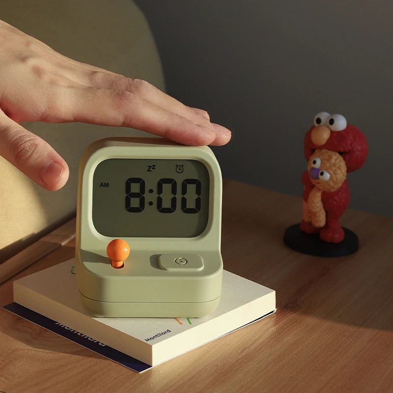 a retro arcade machine alarm clock on a bedside locker