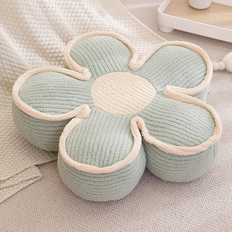 a thick green flower cushion on the floor