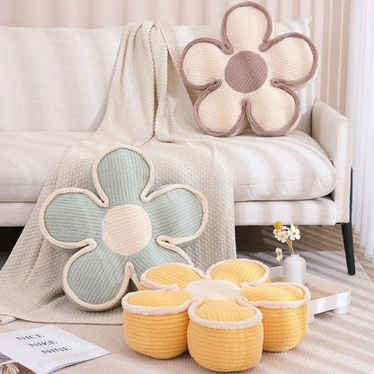 three thick flower cushions, cream, green, and yellow on a couch and the floor