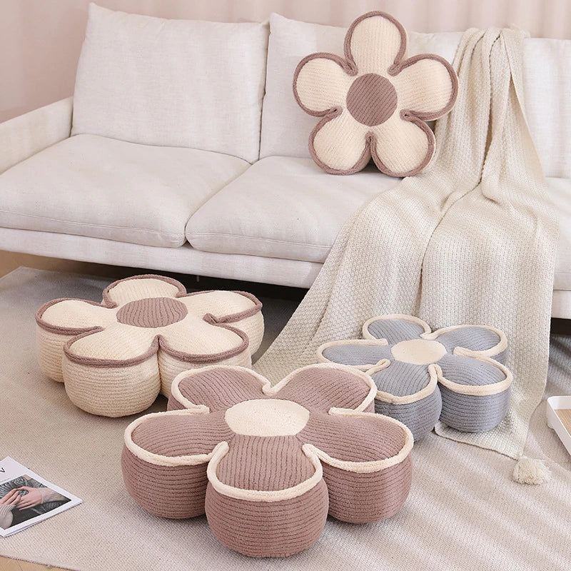 four thick flower cushions, cream, purple, and brown, on a couch and the floor