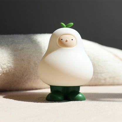 a white silicone cartoon pear night light on a blanket