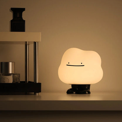 a white silicone cartoon cloud night light on a bedside locker