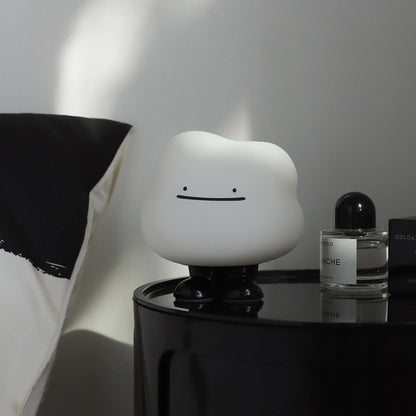 a white silicone cartoon cloud night light on a bedside locker