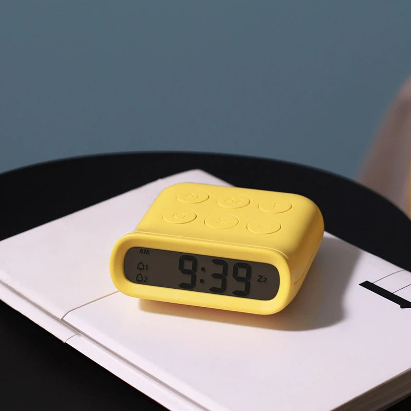 a yellow minimalist digital alarm clock on a notepad