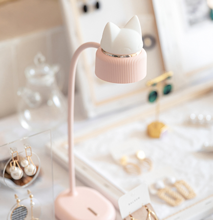 a pink lamp on a desk with a bendable neck, directional light and silicone kitten ear night light