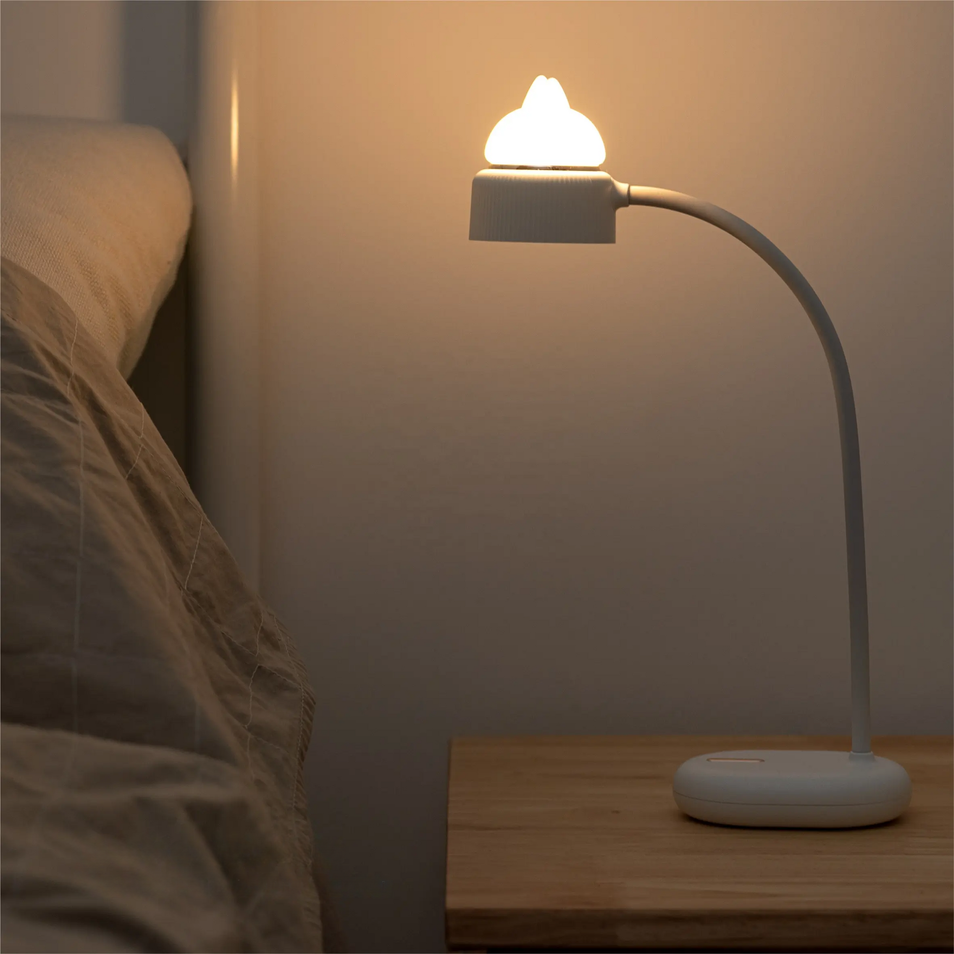 a blue desk lamp with a bendable neck and an independently controlled silicone kitten ear night light which is turned on