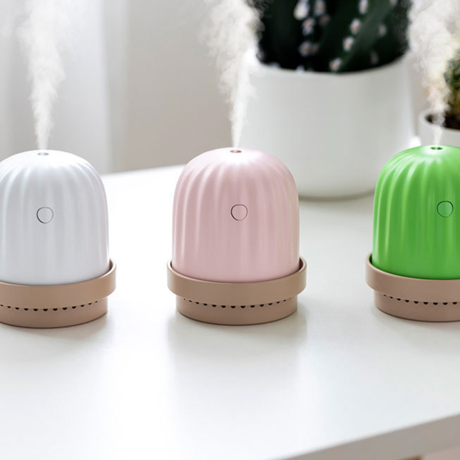 small white, pink, and green cactus humidifiers and night lights releasing vapour