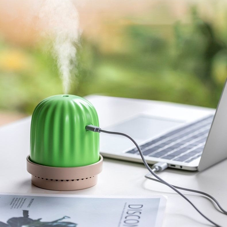 a small green cactus humidifier and night light releasing vapour while charging