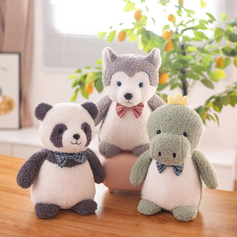 a green dinosaur soft toy, grey siberian husky soft toy and black and white panda bear soft toy all wearing bow ties