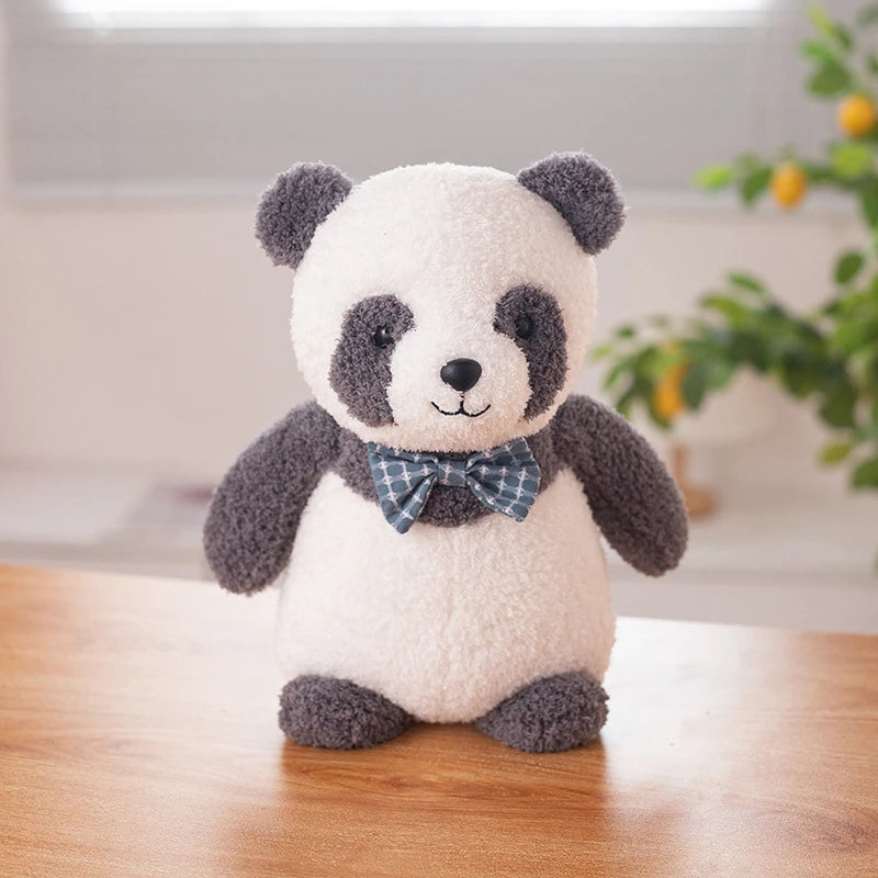 a black and white panda bear soft toy wearing a dark blue bow tie