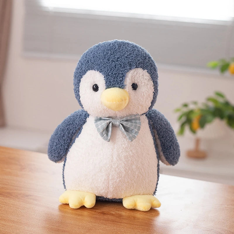 a dark blue penguin soft toy wearing a light blue bow tie