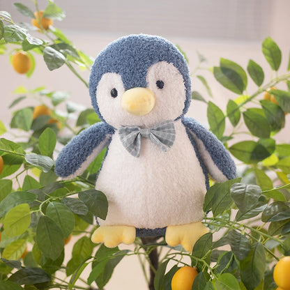 a dark blue penguin soft toy wearing a light blue bow tie in a tree