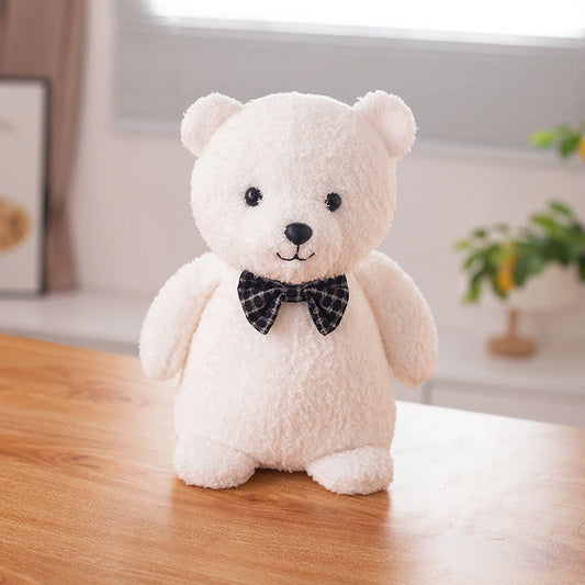 a white polar bear soft toy wearing a black bow tie