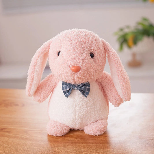 a pink rabbit soft toy wearing a dark blue bow tie