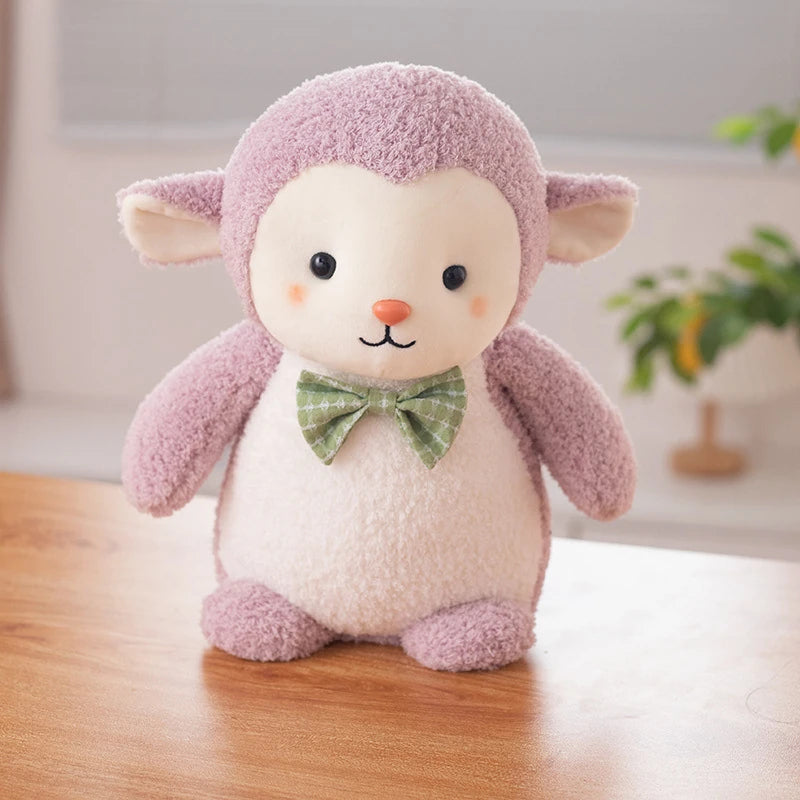 a purple sheep soft toy wearing a green bow tie