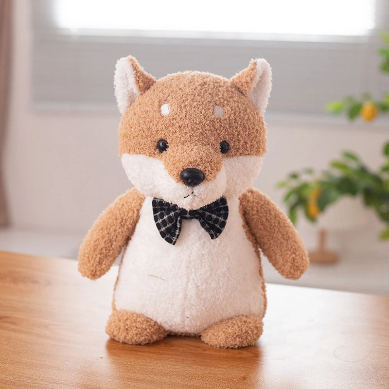 an orange shiba inu soft toy wearing a black bow tie