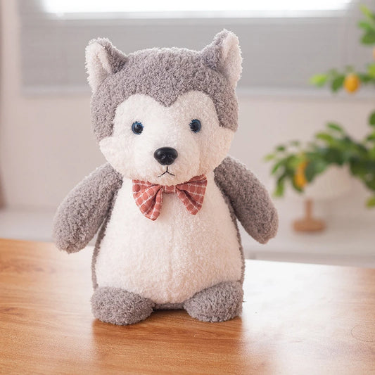 a grey siberian husky soft toy wearing a red bow tie