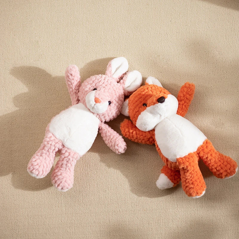 an orange fox soft toy and a pink rabbit soft toy