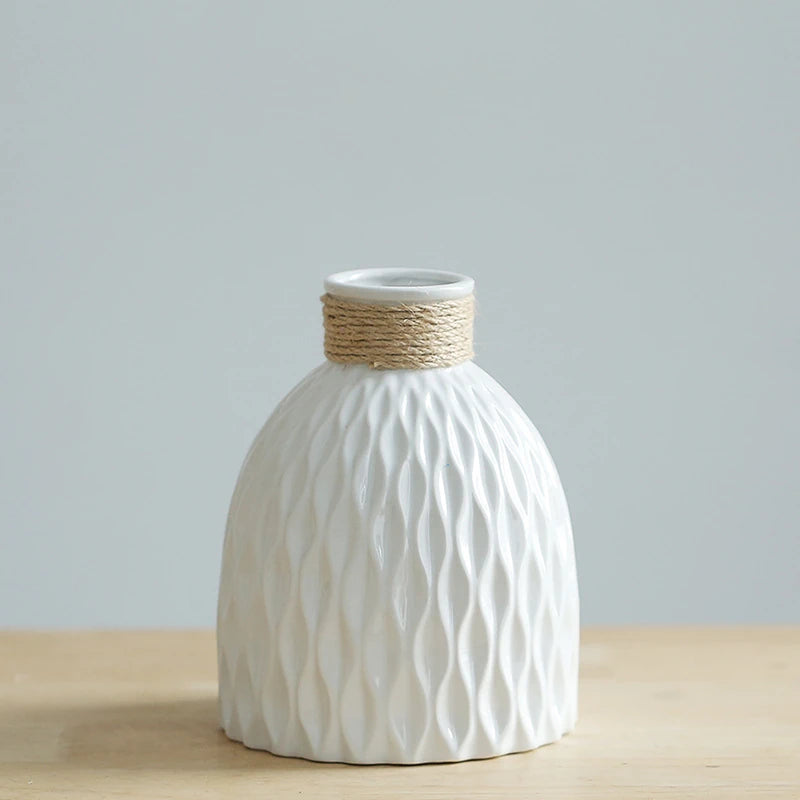 a white vase with a ripple texture and a neck wound with yarn, shaped like a fiasco wine bottle