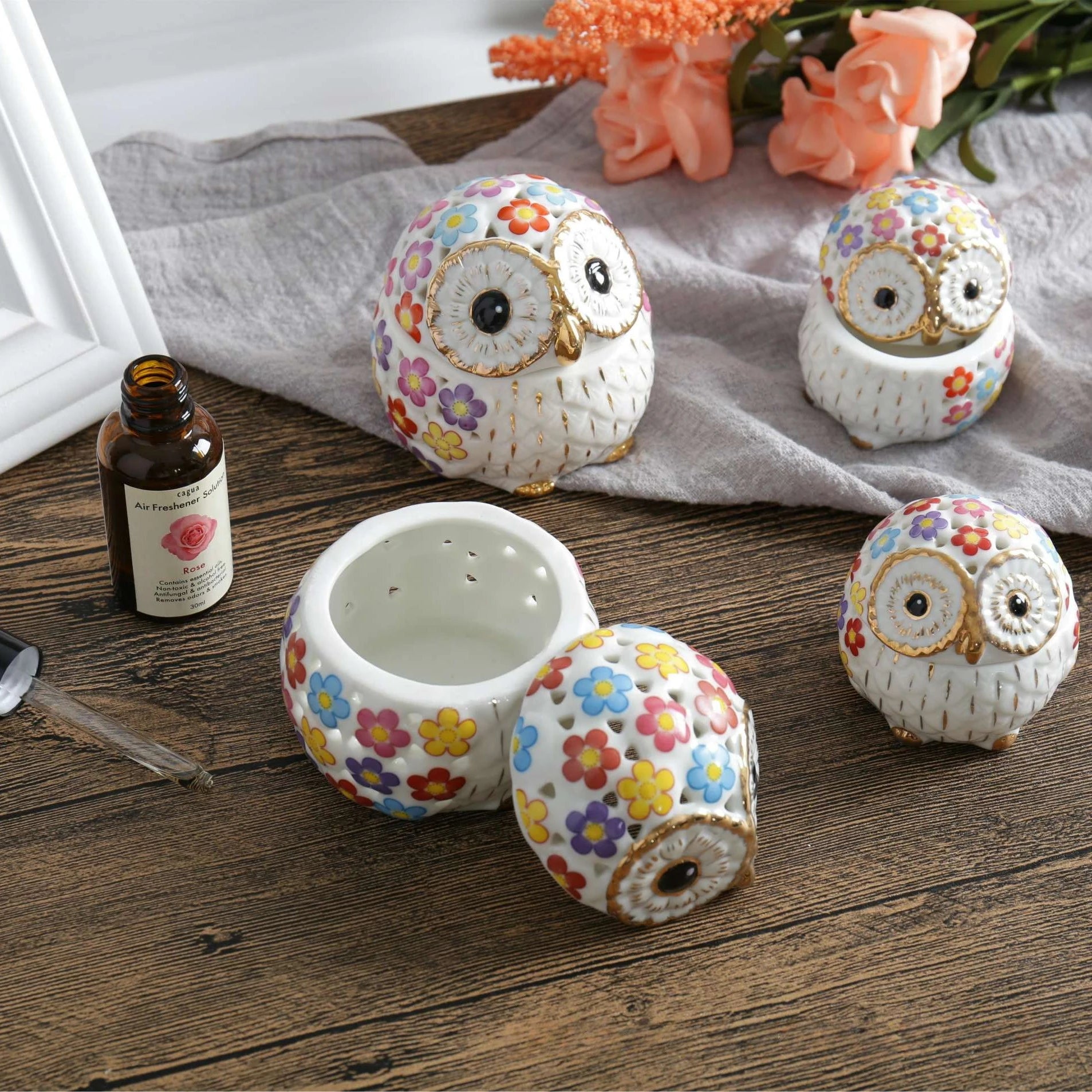 white ceramic owl incense holders with gold highlights and a pink, yellow, purple, blue, and red flower pattern