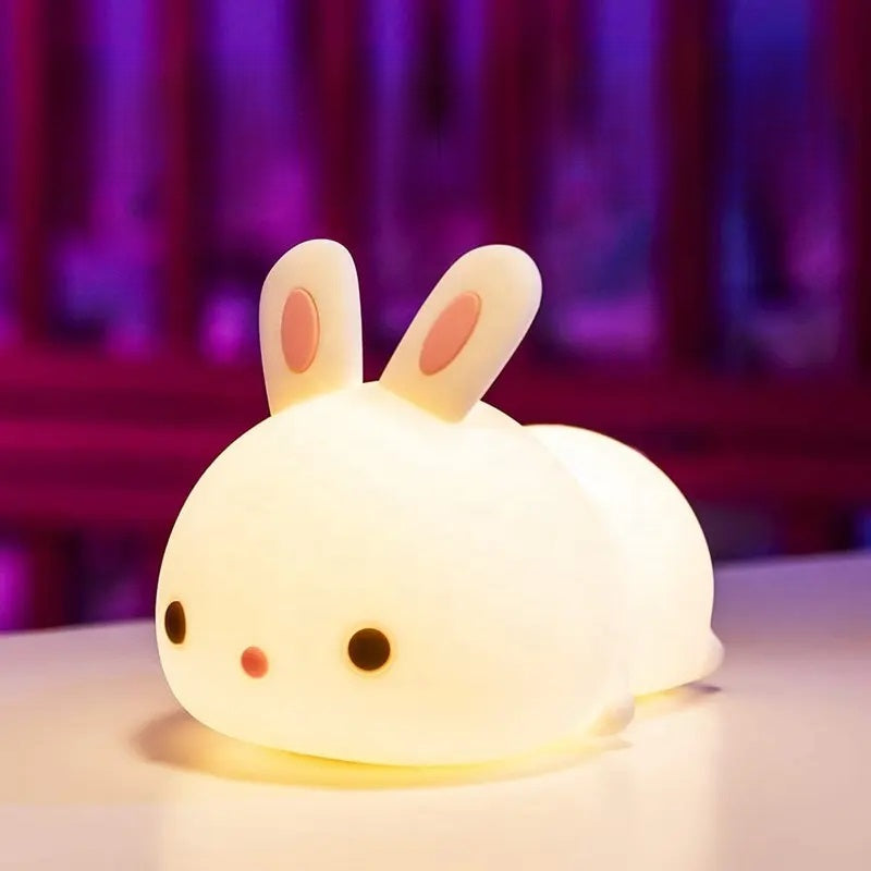 a white silicone cartoon bunny night light on a bedside locker