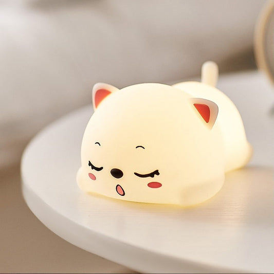 a white silicone cartoon cat night light on a bedside locker