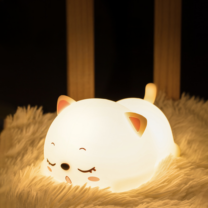 a white silicone cartoon cat night light in a baby cot